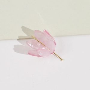 Détail d'un pétale de fleur rose translucide avec une tige en métal doré