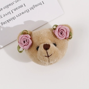 Cute brown plush bear DIY accessory with pink satin rose flowers on a white background