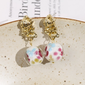 Vintage gold textured metal earrings with floral glass beads in a boho artistic style