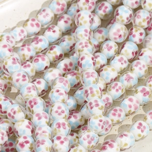 Close-up of 14mm floral glass beads with colorful flower patterns for DIY jewelry making