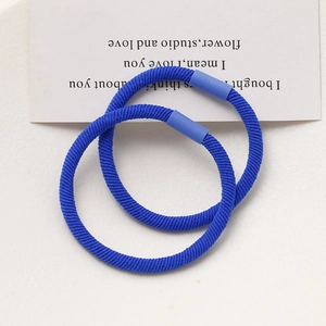 Close-up of two high-elastic woven hair ties in Klein blue with plastic joints