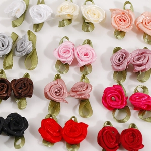 Detailed grid view of assorted colorful satin ribbon roses with green fabric leaves