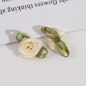Detailed close-up of handmade polyester ribbon rose buds with green fabric leaves