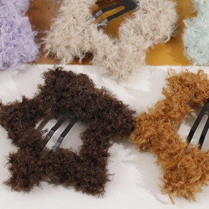 Close-up of colorful plush star hair clips with soft lamb wool texture and metal clips