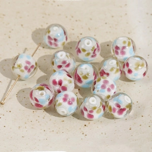 Detailed macro view of 14mm floral glass bead with a gold pin through the center hole