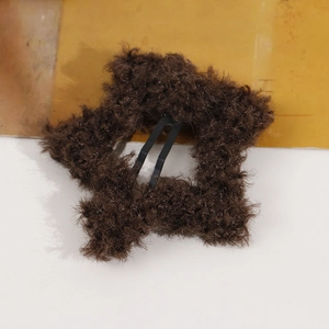 Detail of dark brown plush star hair clip with soft faux fur texture and metal BB clip