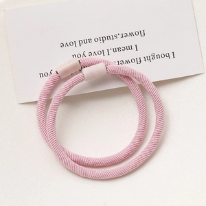 Close-up of pink elastic hair ties with woven texture and smooth cylindrical buckles