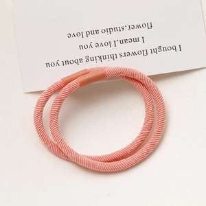 Close-up of pink high-elasticity hair ties with plastic joints on a minimalist background