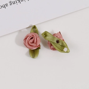 Detail of handmade pink ribbon roses with green leaves for DIY garment accessories