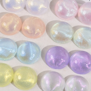 Macro detail of round iridescent glitter resin cabochons in pastel macaron colors