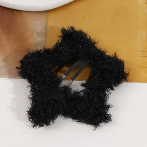 Detail of a sweet star-shaped hair clip with soft black plush fur and metal BB snap