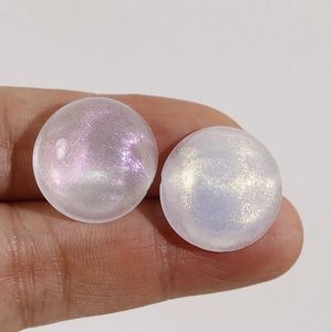 Detail of round acrylic charms with iridescent aurora glitter for DIY jewelry crafts