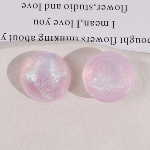 Macro shot of pink glitter semi-round acrylic cabochon charms for DIY jewelry making