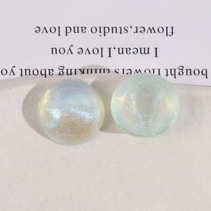 Macro shot of iridescent resin half-sphere charms with glitter for DIY jewelry