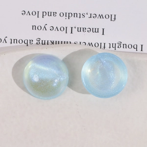 Close-up of sky blue round acrylic cabochons with glitter and iridescent shimmer