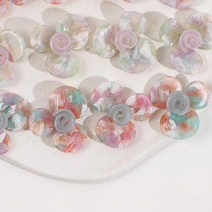 Makro-Detail von Acetat-Blumenanhängern mit Marmorstruktur und Spiralstempel für DIY-Schmuck