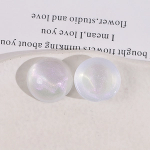 Macro shot of circular resin cabochons with iridescent aurora glitter and cat-eye effect