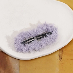 Detailed view of plush purple faux fur hair clip with black metal snap closure