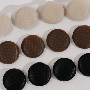 Flat lay of 17mm grid textured round metal buttons in beige, brown, and black tones