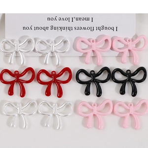 Detailed view of DIY bow-shaped charms in pearl white, pink, red, and black with top loops