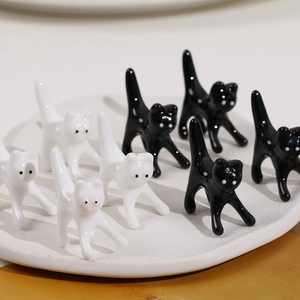 Dettaglio di simpatici gatti in ceramica 3D bianchi e neri con finitura smaltata lucida