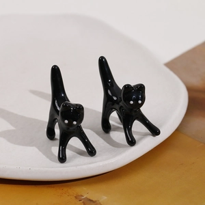 Dettaglio di due statuette di gatto in ceramica nera lucida come porta anelli per gioielli