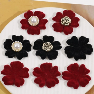 Dettaglio di fiori in velluto rosso e nero con perle e centri dorati per gioielli fai da te