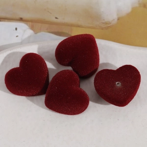 Détail de quatre perles de cœur en résine floquée bordeaux pour bijoux DIY