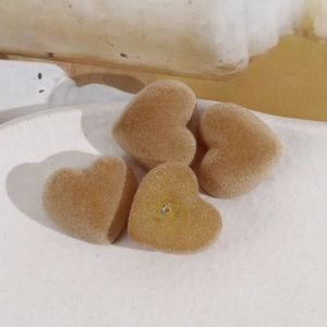 Détail de quatre breloques cœur floquées camel en résine pour la création de bijoux