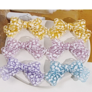Detailed view of colorful acetic acid bow charms with checkered mosaic patterns for DIY