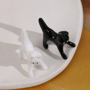 Vista macro di figurine di gatti in ceramica bianca e nera usate come portapenne decorativi