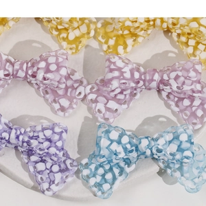 Close-up of assorted colorful acetate bow hair clips with white ripple patterns