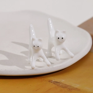 Primo piano di due graziose statuette di gatti in ceramica bianca dal design minimal