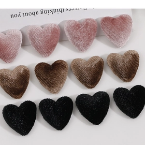 Close-up of heart-shaped plush buttons in pink, brown, and black for DIY hair accessories