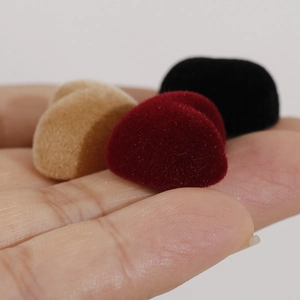 Comparaison de taille montrant les charms cœur floqués bordeaux, beige et noir en main
