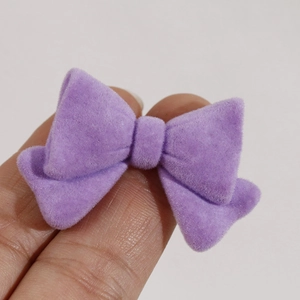 Close-up of small purple flocked bow resin charm for DIY hair accessories and nail art