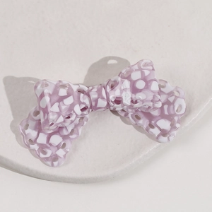 Close-up of purple checkered acetic acid bow hair clip with hollow round hole design