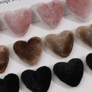Close-up of soft velvet heart buttons in pink, brown, and black for DIY craft projects