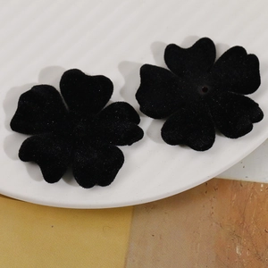 Dettaglio di ciondoli a fiore nero floccato su vassoio in ceramica per gioielli fai da te