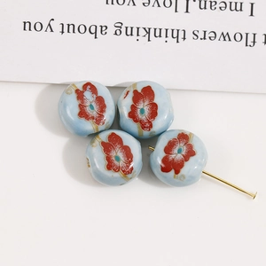 Detailed macro view of 12mm floral ceramic beads with red flowers for DIY jewelry making