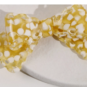 Macro shot of two-tone acetate bow with yellow and white stone texture detail