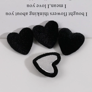 Detailed view of heart-shaped black flocked metal buttons for DIY jewelry making