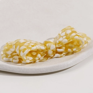 Close-up of a large yellow and white checkered bow hair clip on a display tray