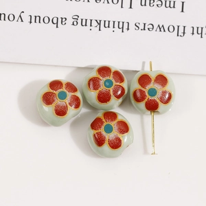 Detailed macro view of 12mm floral ceramic beads with vintage red petals for DIY jewelry