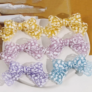 Colorful acetate bow hair clips in yellow and purple with mesh cutout patterns