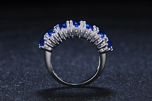Macro detail of silver ring with two rows of deep blue zircons and small clear crystals