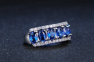 Macro view of row-set oval blue zircons with white diamond accents on silver band