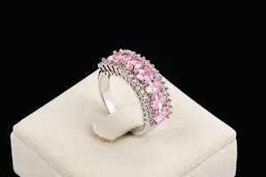 Dettaglio di pietre ovali rosa circondate da piccoli diamanti bianchi su anello argento