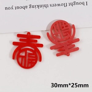 Close-up of red glitter acrylic DIY pendant with festive hollowed-out Chun and Fu characters