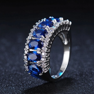 Elegant silver wide band ring featuring five oval blue AAA zircons with diamond accents